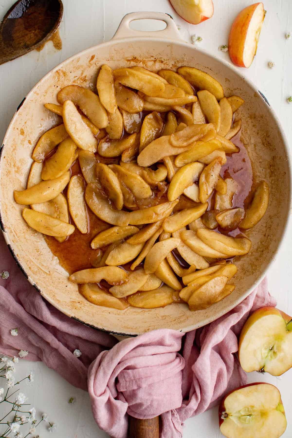 Manzanas cocidas en una sartén con mantequilla, azúcar y canela.