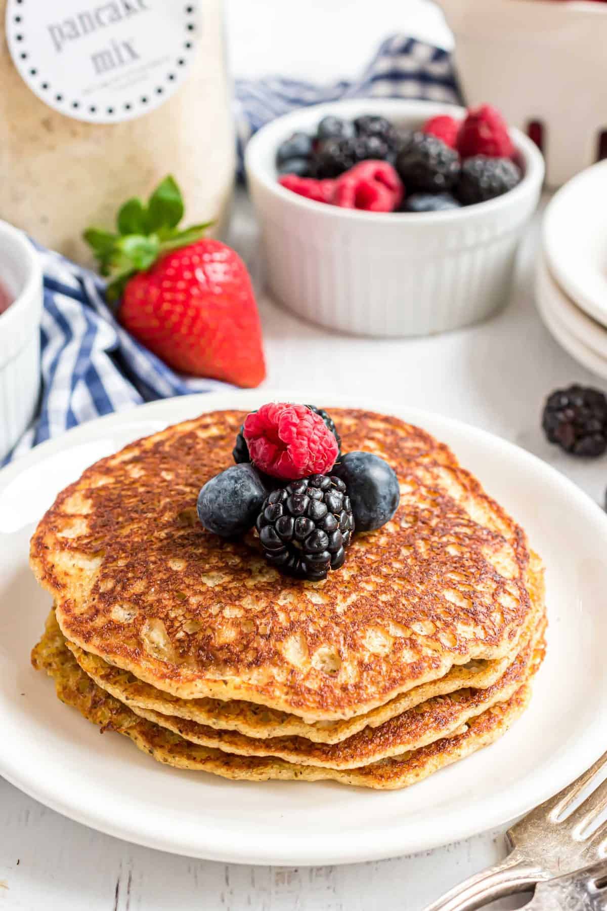 Panqueques keto con un frasco de mezcla de panqueques en el fondo.