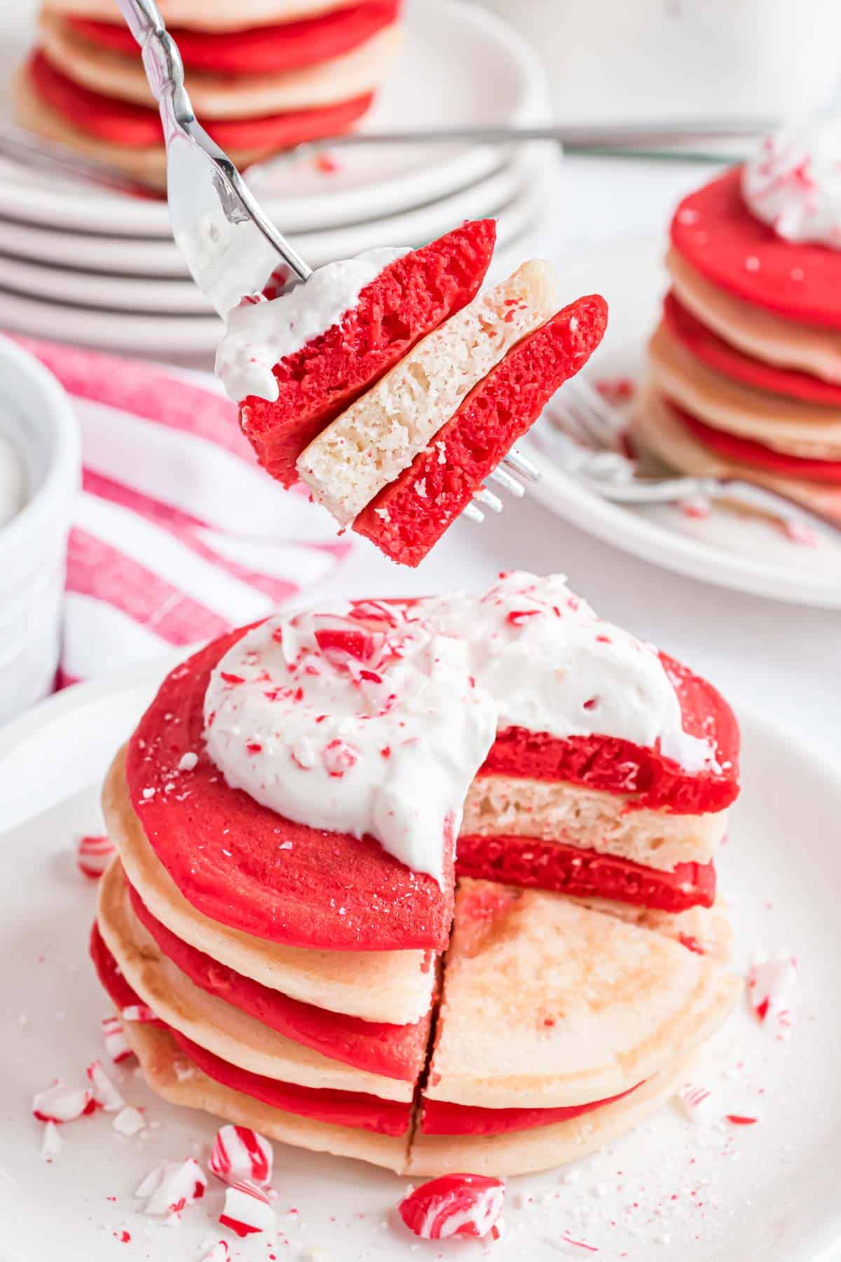 Panqueques rojos y blancos en un tenedor para mostrar su textura esponjosa.