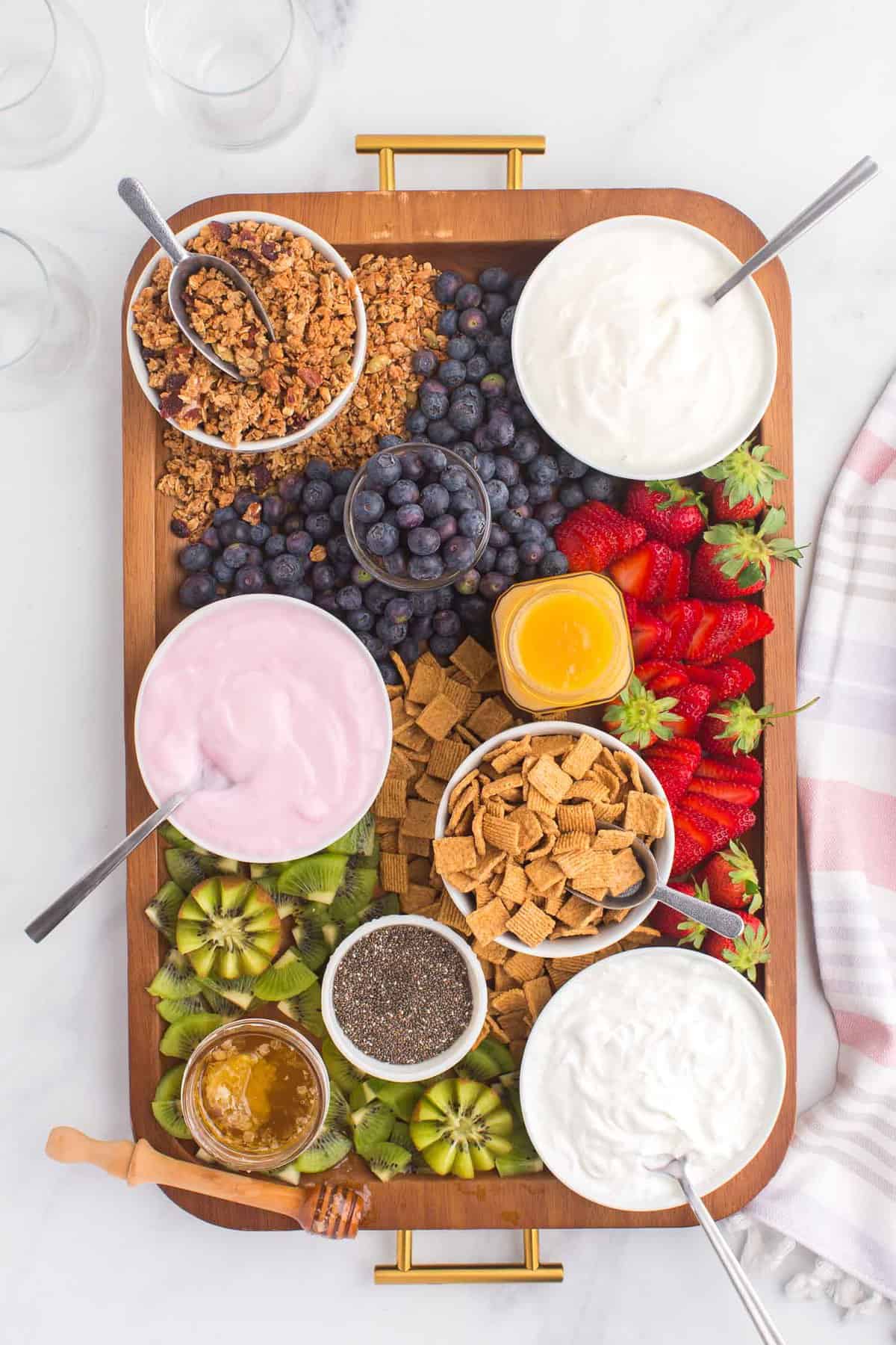 Vista aérea de la tabla de charcutería de yogurt con tres tipos de yogurt.