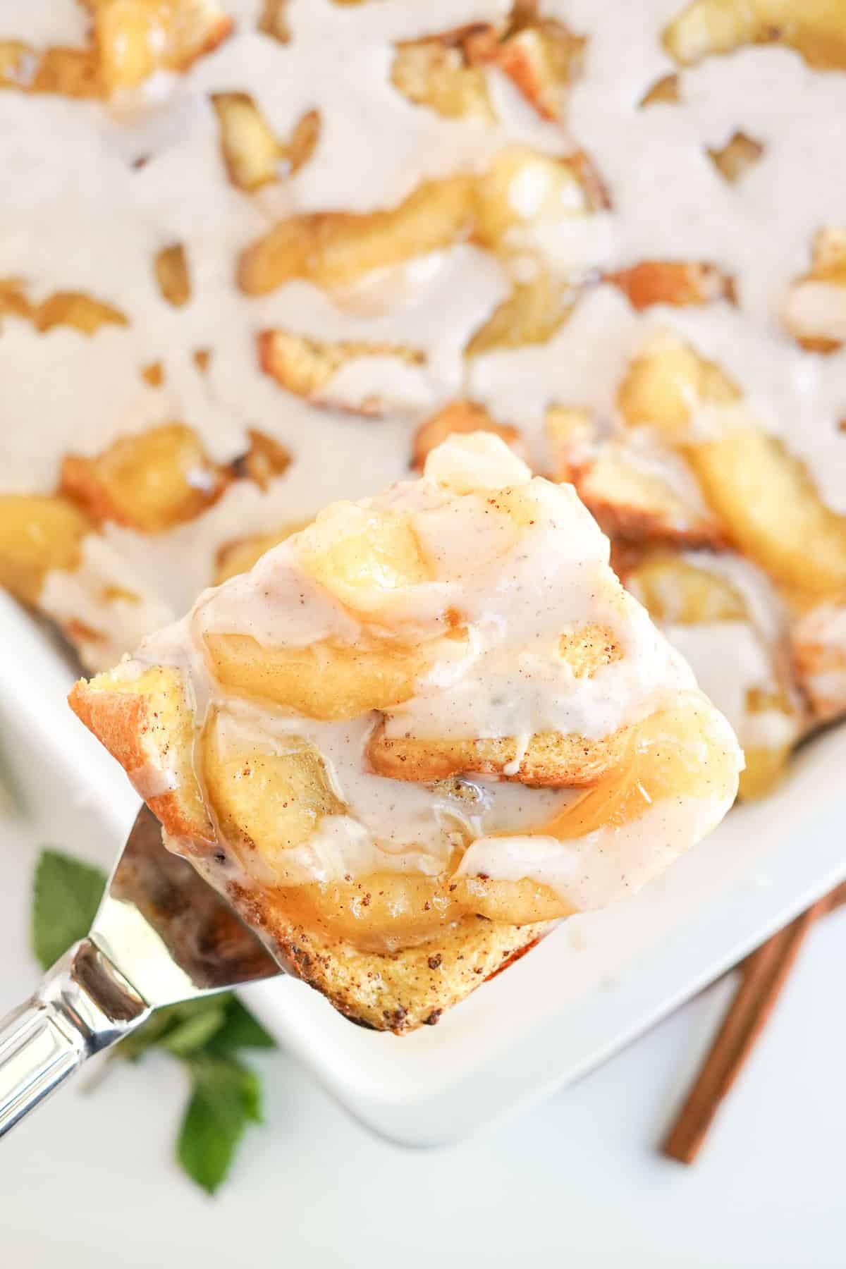 Una porción de cazuela de panqueques franceses de manzana siendo retirada del plato.
