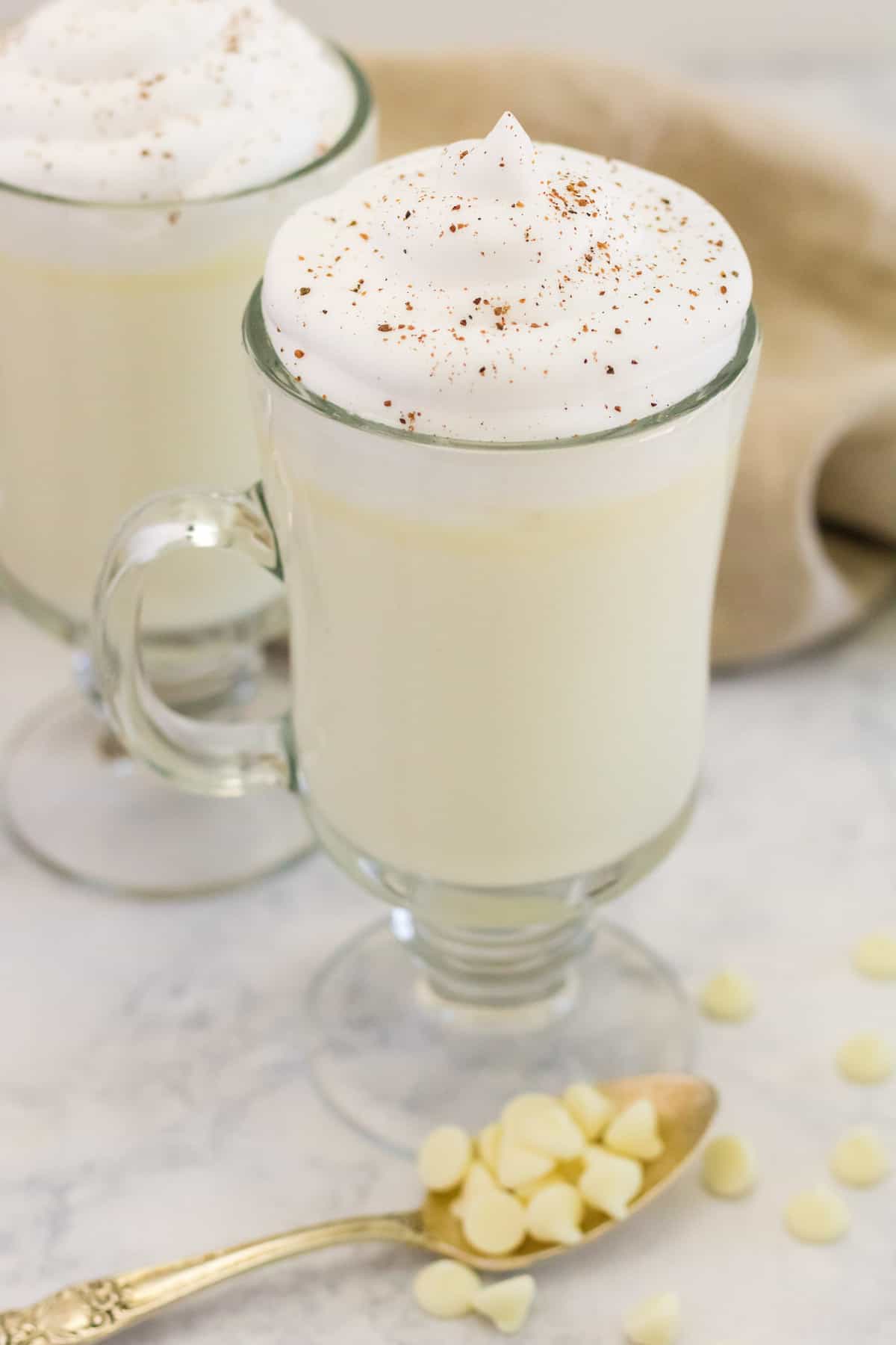 Chocolate blanco caliente en una taza de cristal transparente.