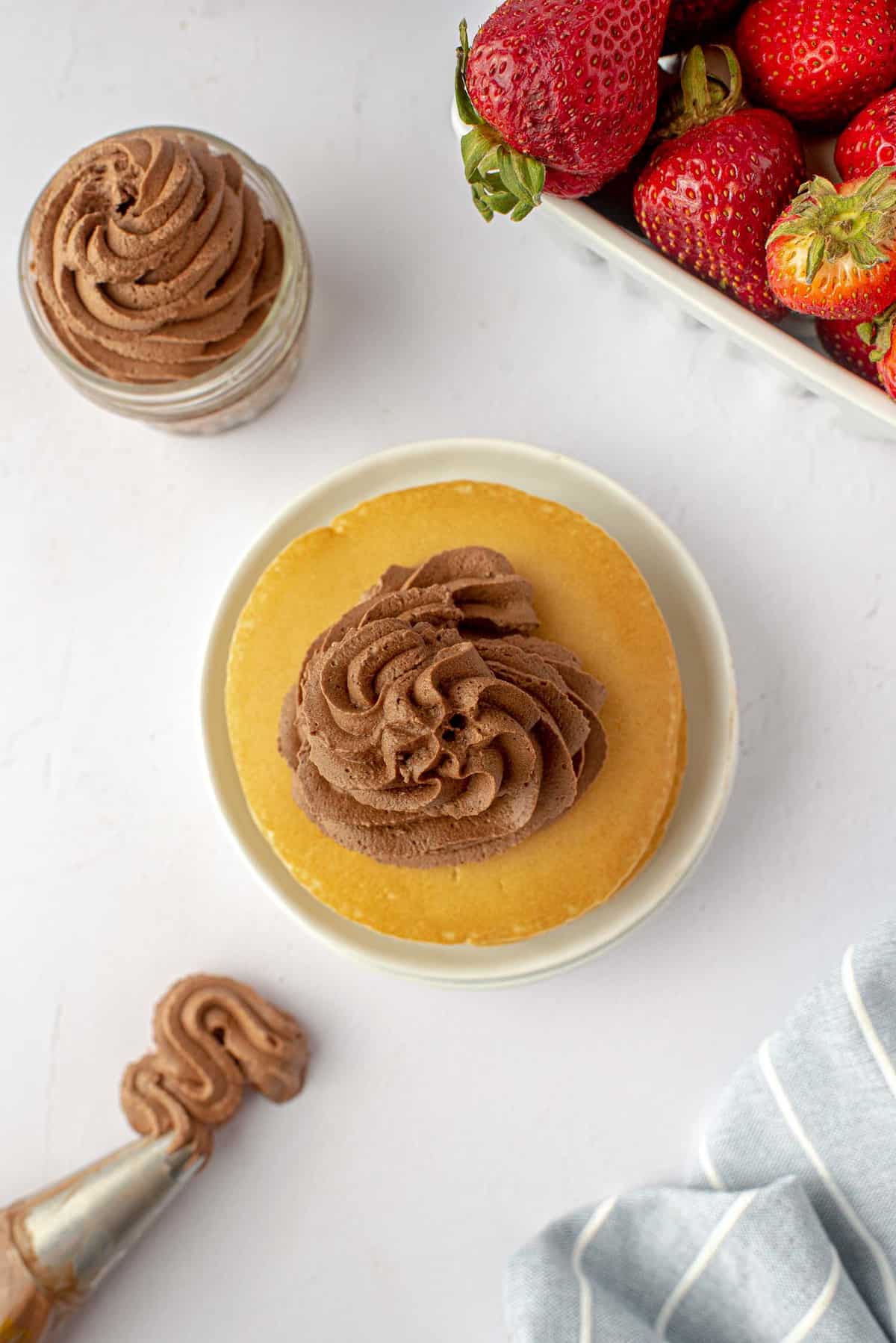 Crema de chocolate batida sobre panqueques y en un pequeño frasco.