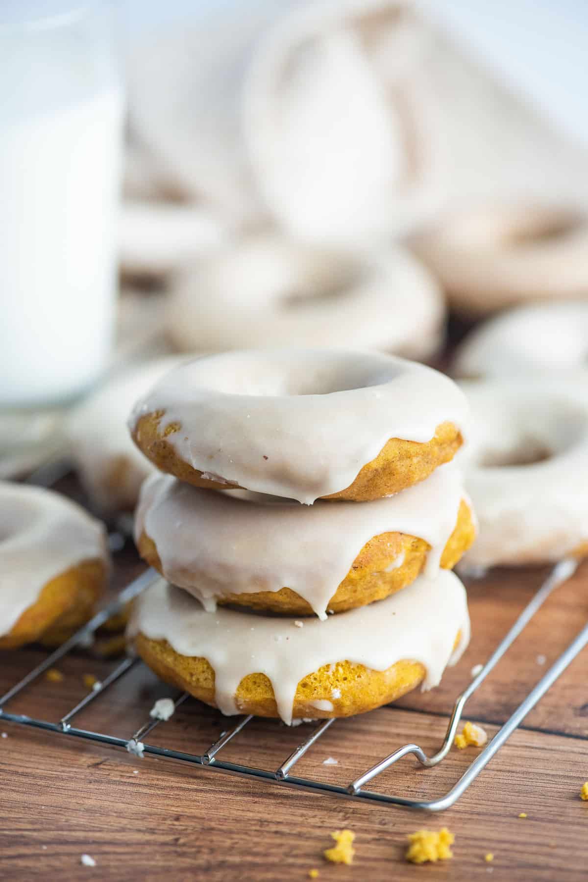 Tres panqueques de calabaza con glaseado, más en el fondo.