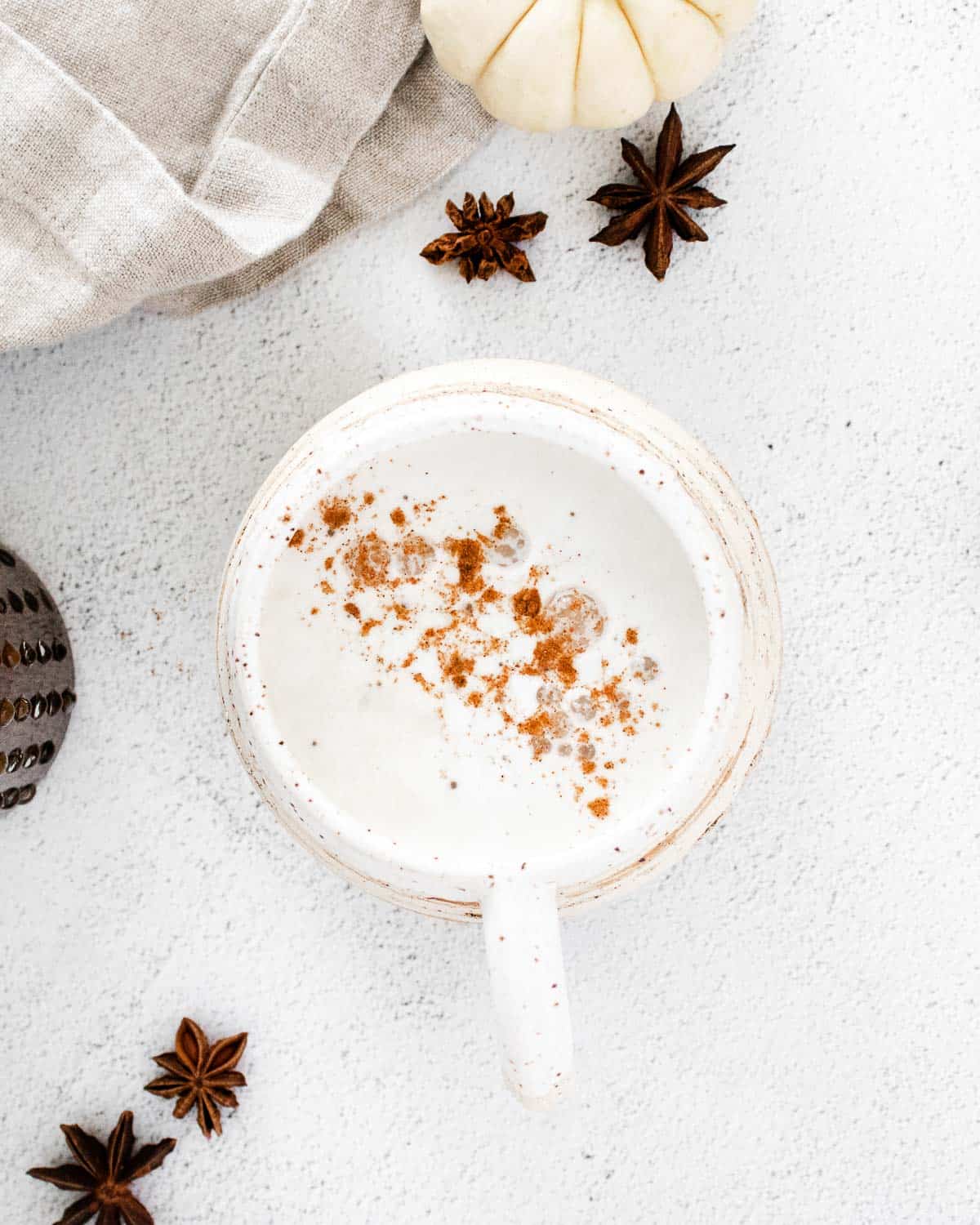 Vista aérea de un latte espolvoreado con especias de tarta de calabaza.