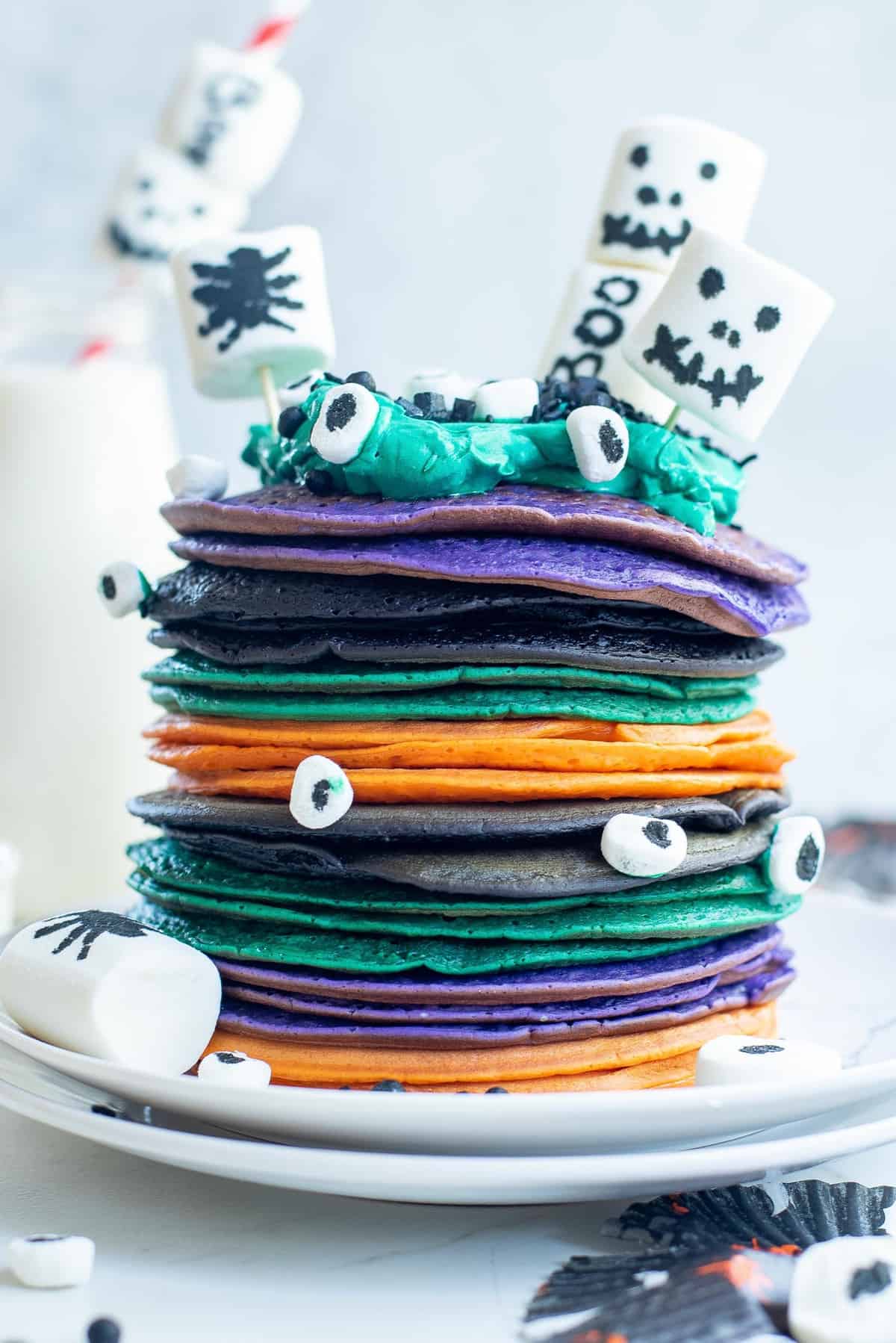 Montón de panqueques de Halloween multicolores con malvaviscos decorados.