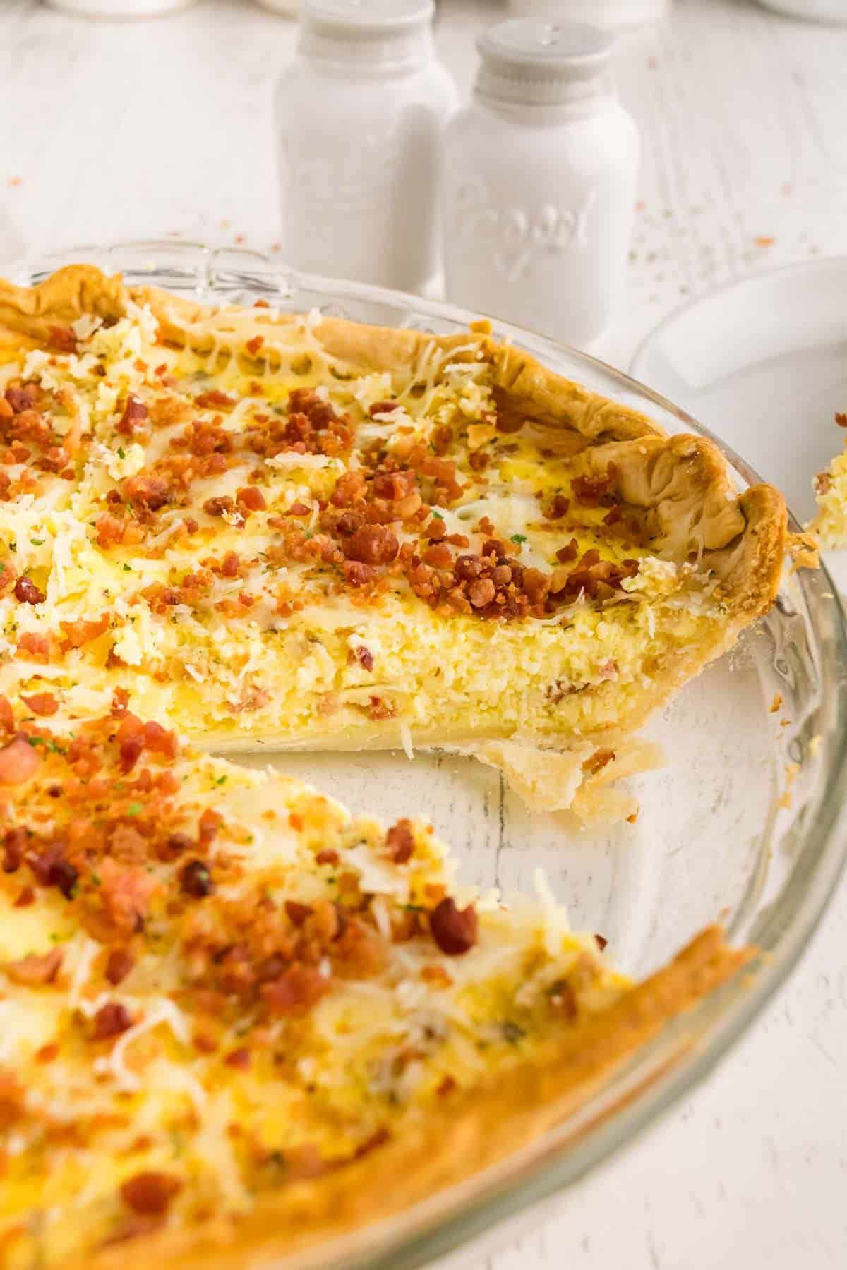 Quiche con bacon, una porción retirada del molde.