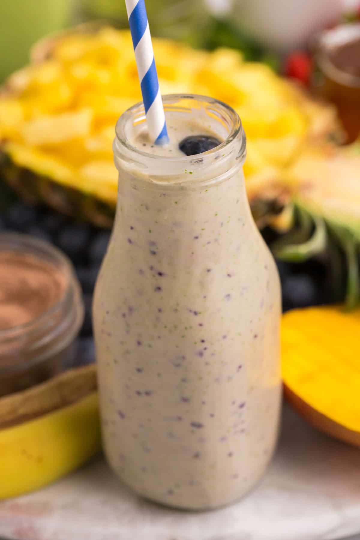 Primer plano de un batido de chocolate y plátano con una pajita de papel.