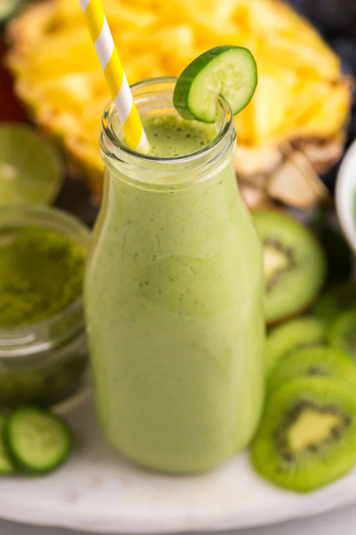 Primer plano de un batido verde con una pajita amarilla y blanca.