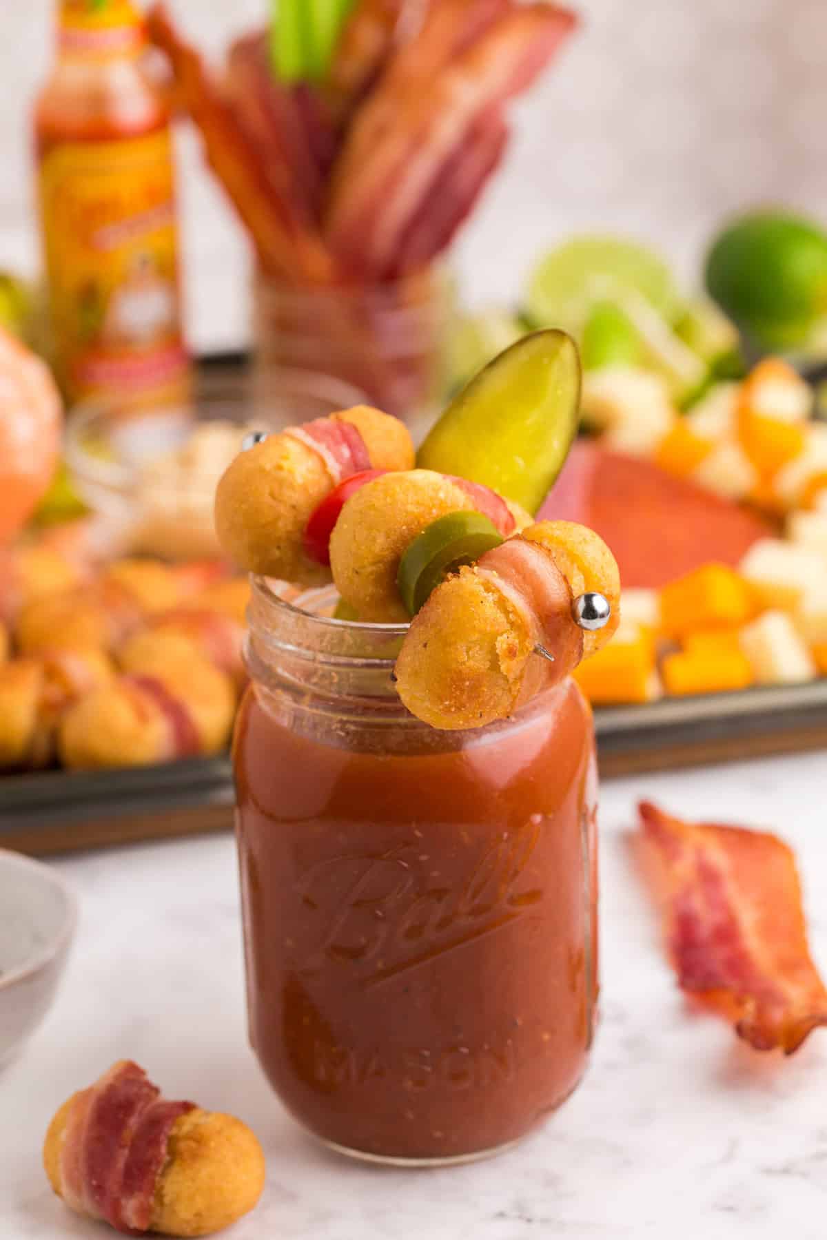 Bloody Mary decorado con mini corndogs envueltos en tocino.