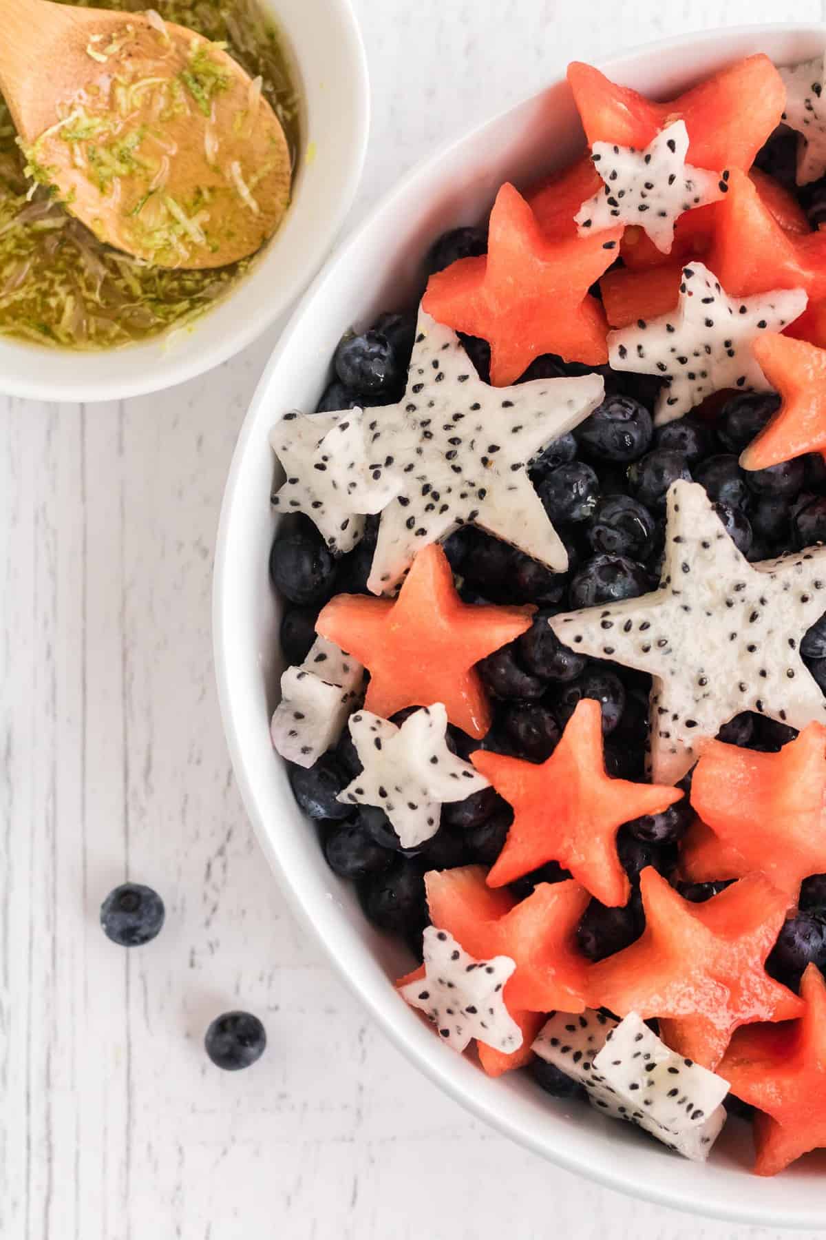 Cerca de vista de ensalada de frutas con sandía y pitaya cortadas en formas de estrella.