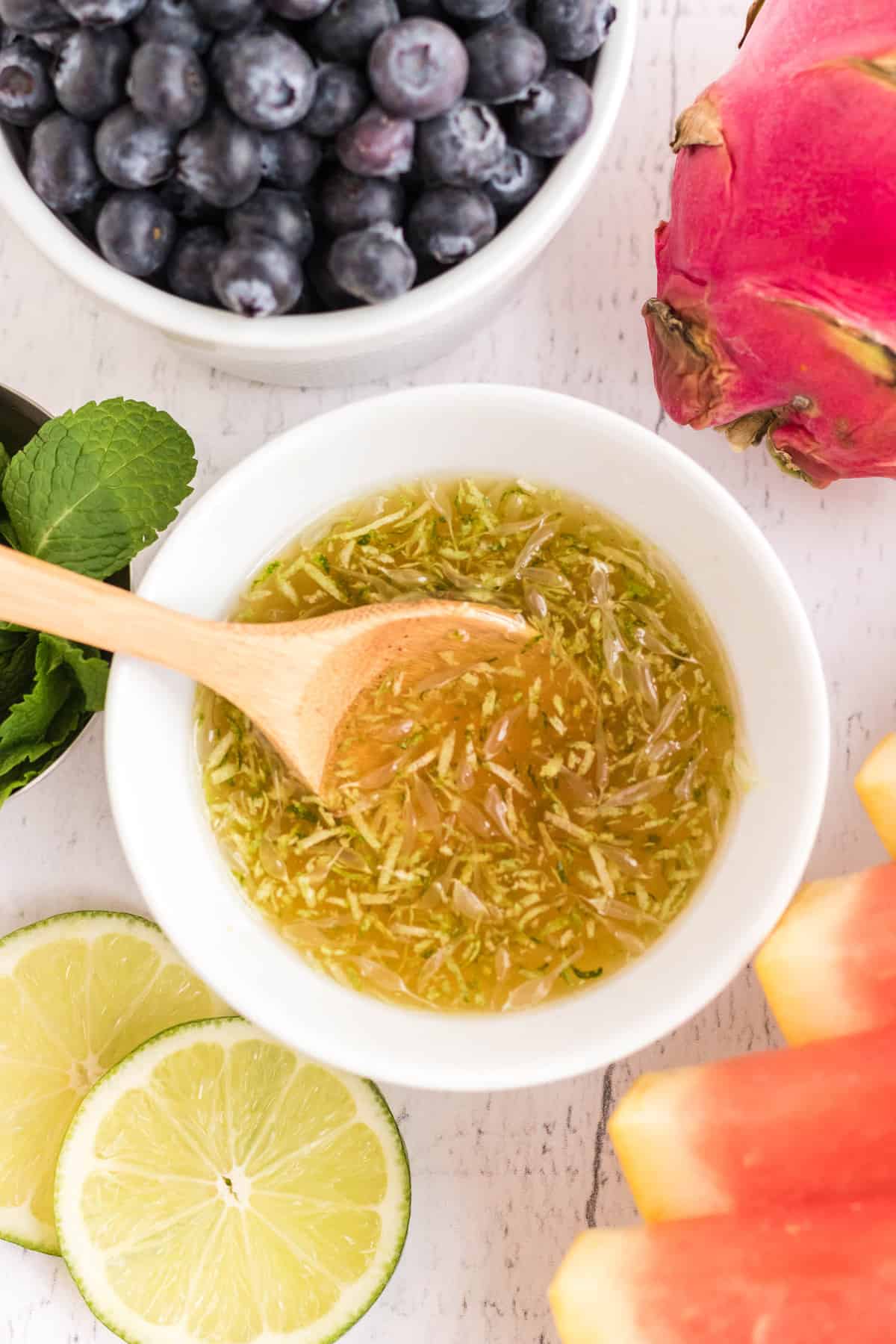 Aderezo de ensalada de frutas en un pequeño tazón blanco.