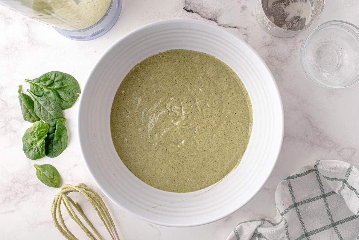 Masa de panqueque verde en un tazón blanco de mezcla.