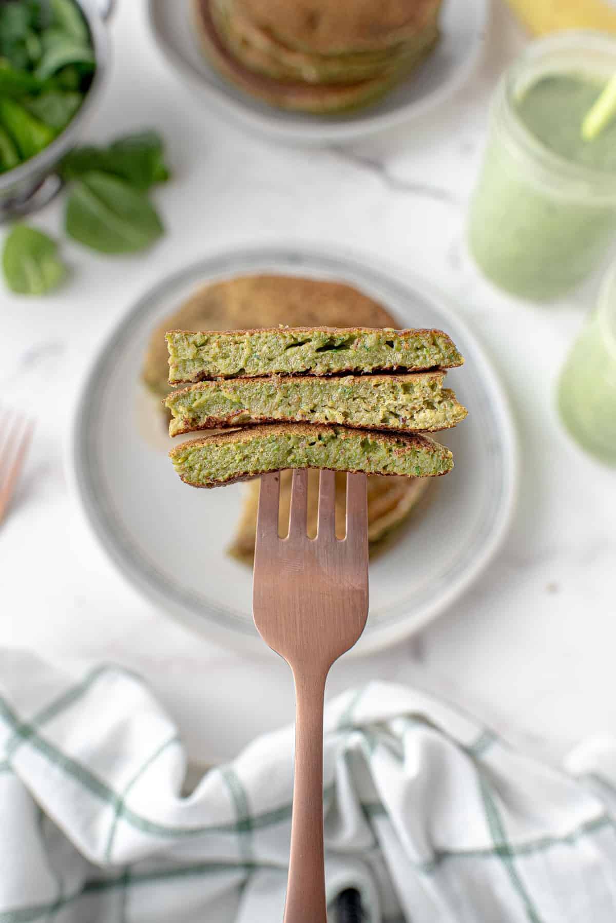 Panqueques de smoothie verde cortados en un tenedor.