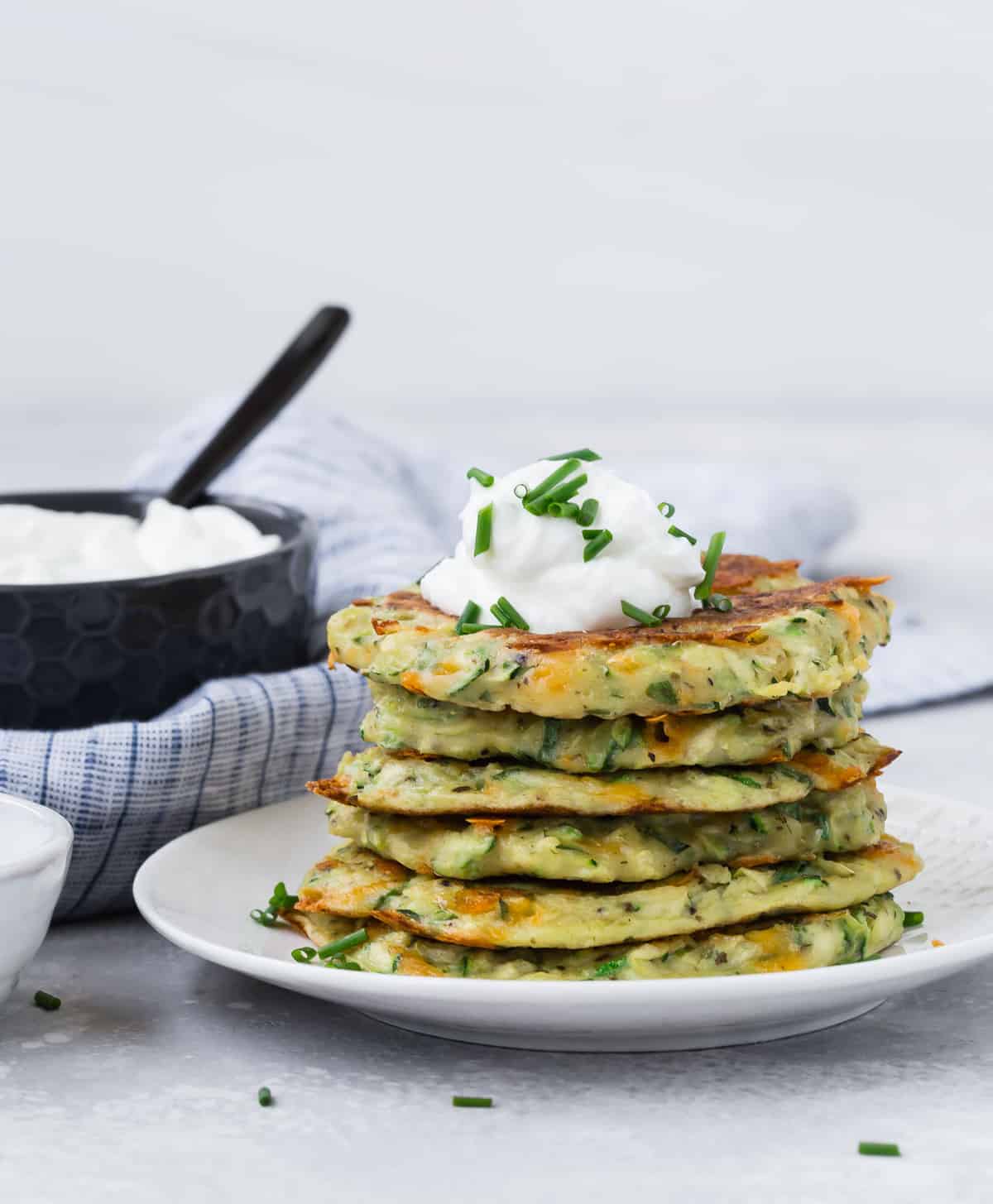 panqueques de calabacín apilados en un plato blanco.