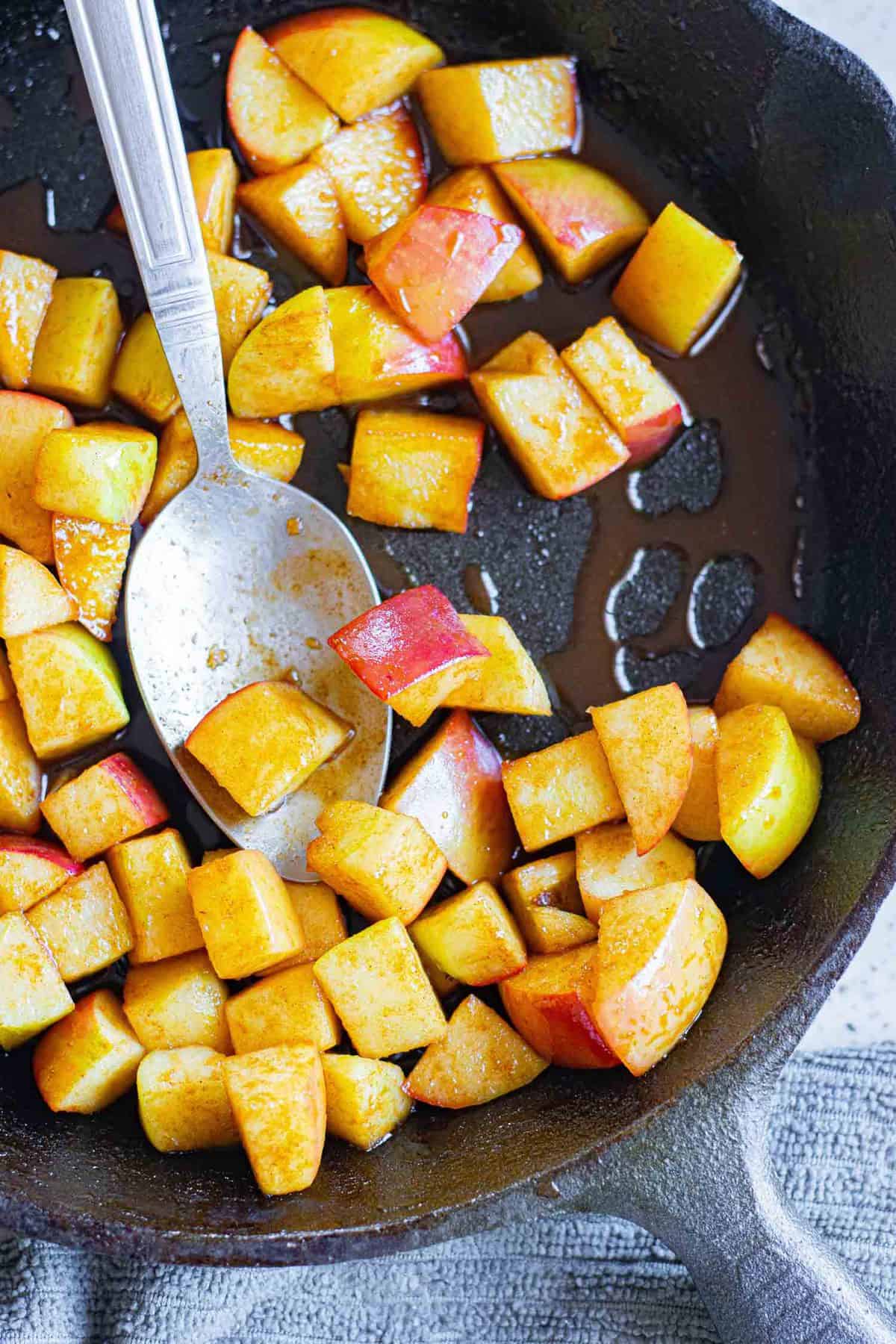 Manzanas salteadas en una sartén negra.
