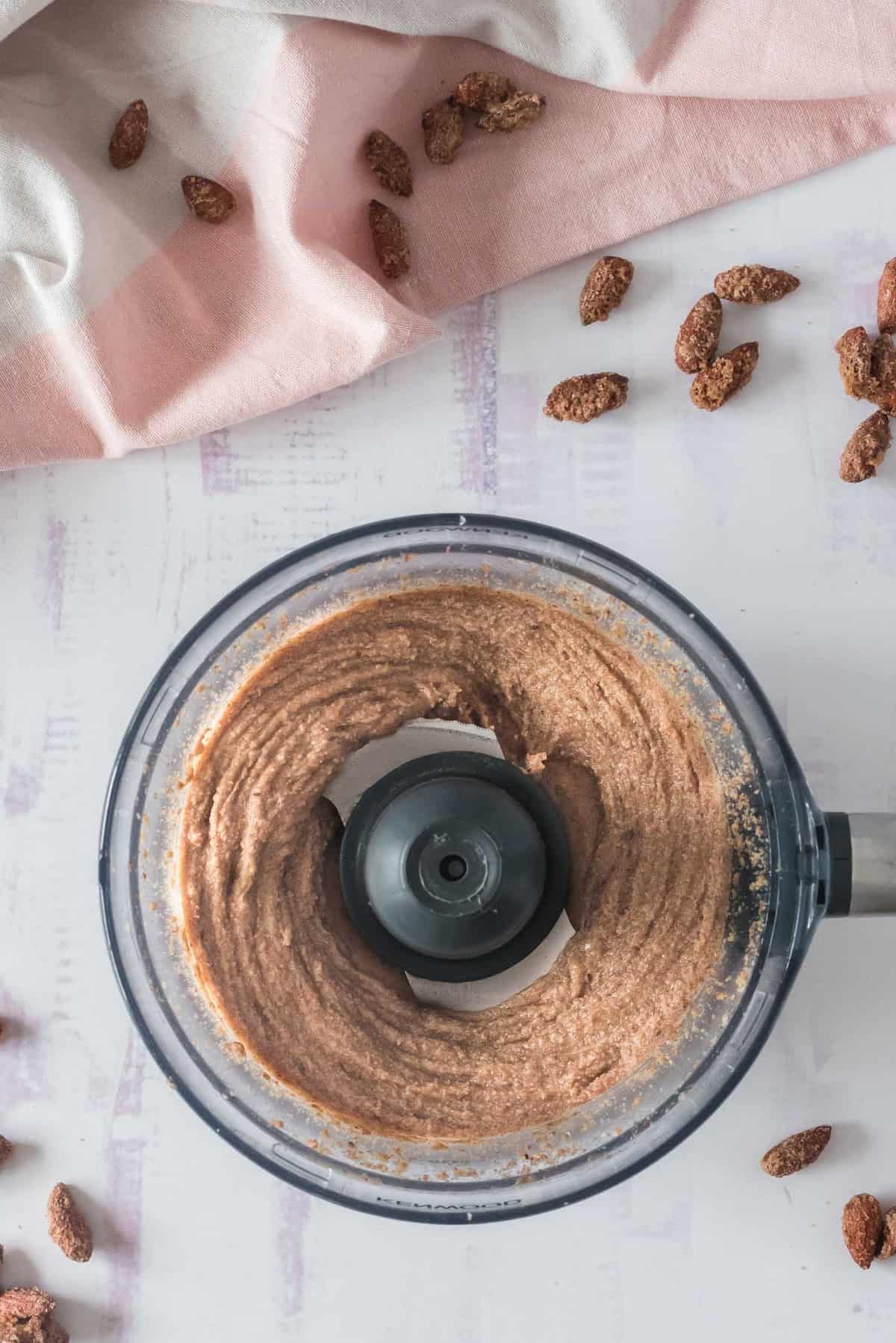 Mantequilla de almendra parcialmente mezclada en un procesador de alimentos.