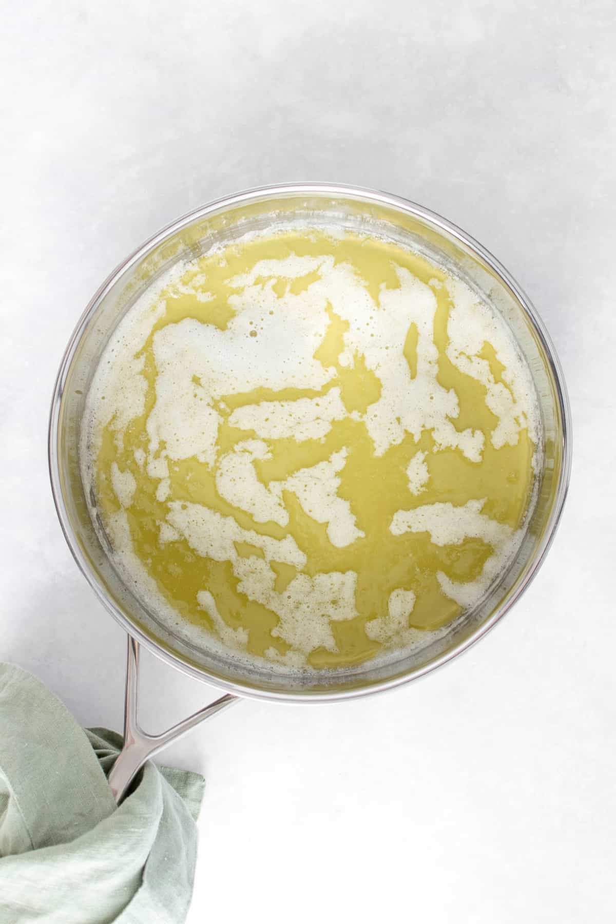 Mantequilla derretida en una sartén de acero inoxidable.