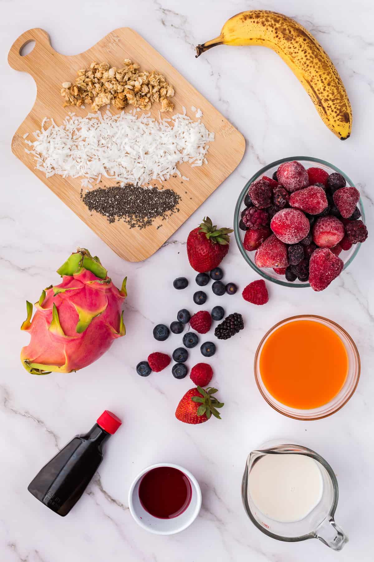 Ingredientes necesarios para la receta, incluyendo bayas mixtas congeladas y un plátano.