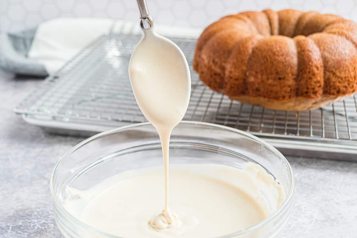Glaseado de queso crema goteando de una cuchara.