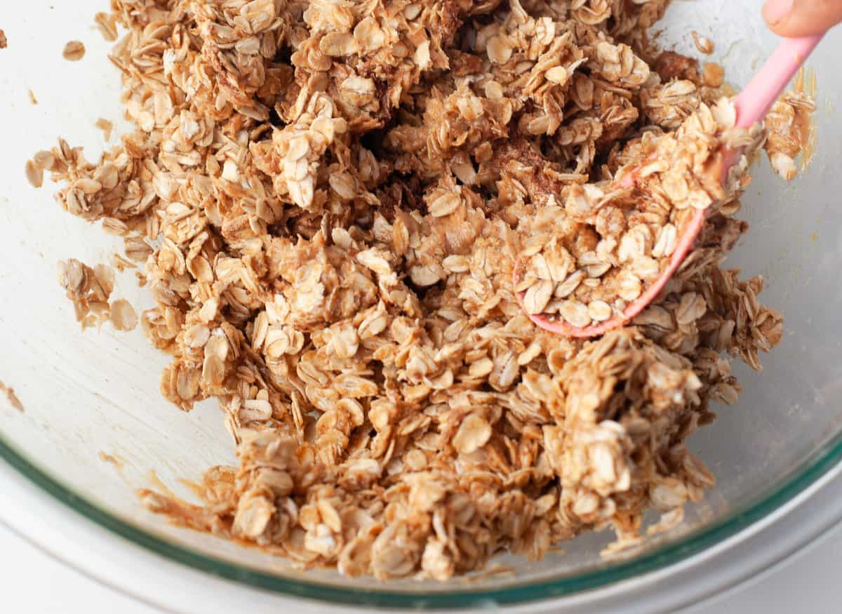 Mezcla de avena en un bol de vidrio con cuchara de madera.