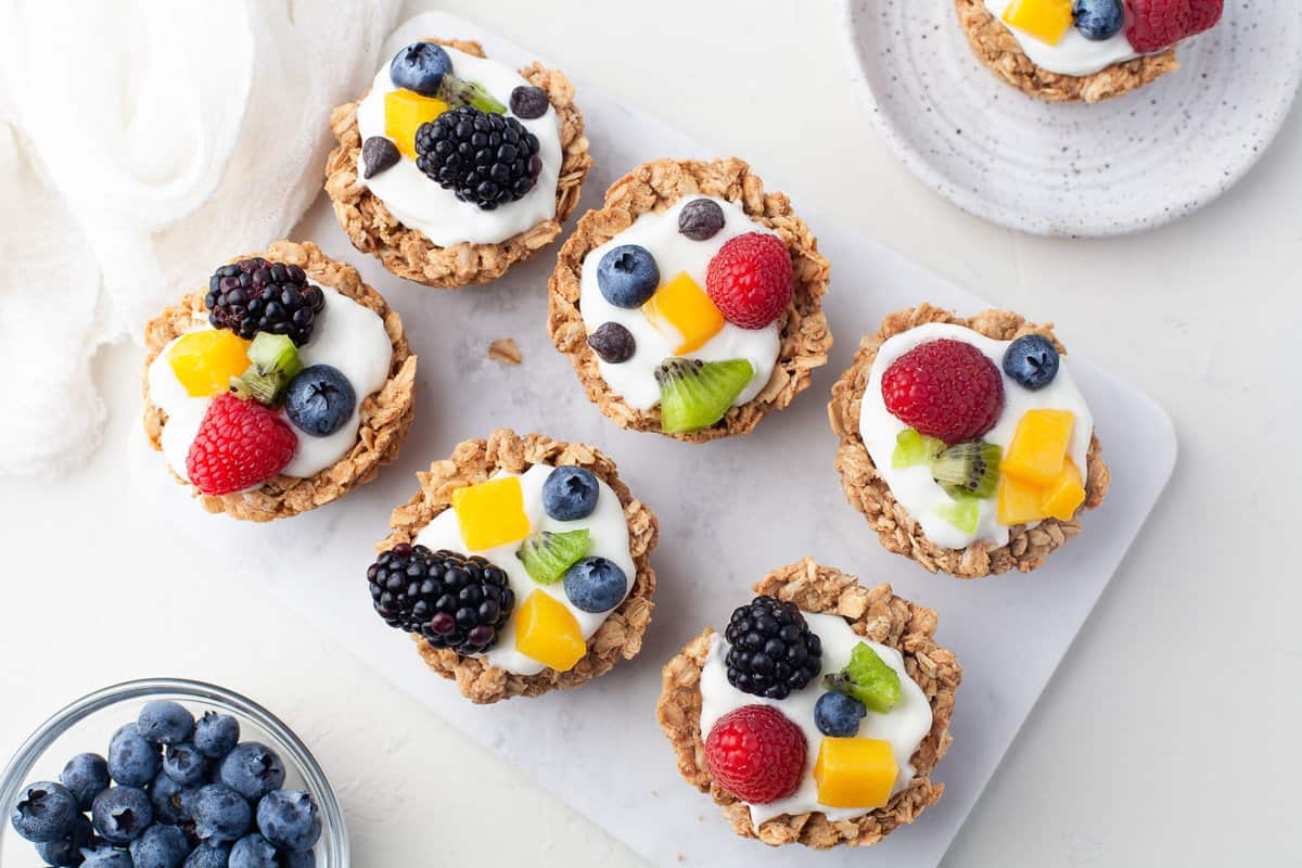 Cups de avena con diferentes frutas en la parte superior.