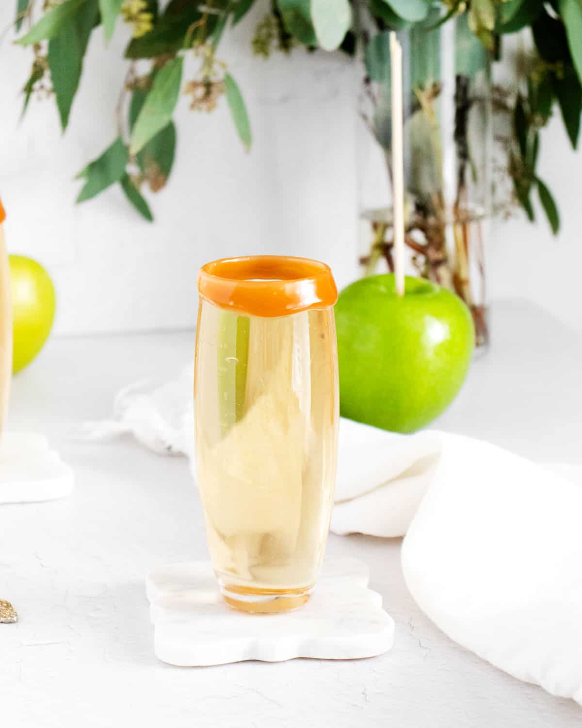 Una mimosa hecha con sidra de manzana, una manzana en el fondo.