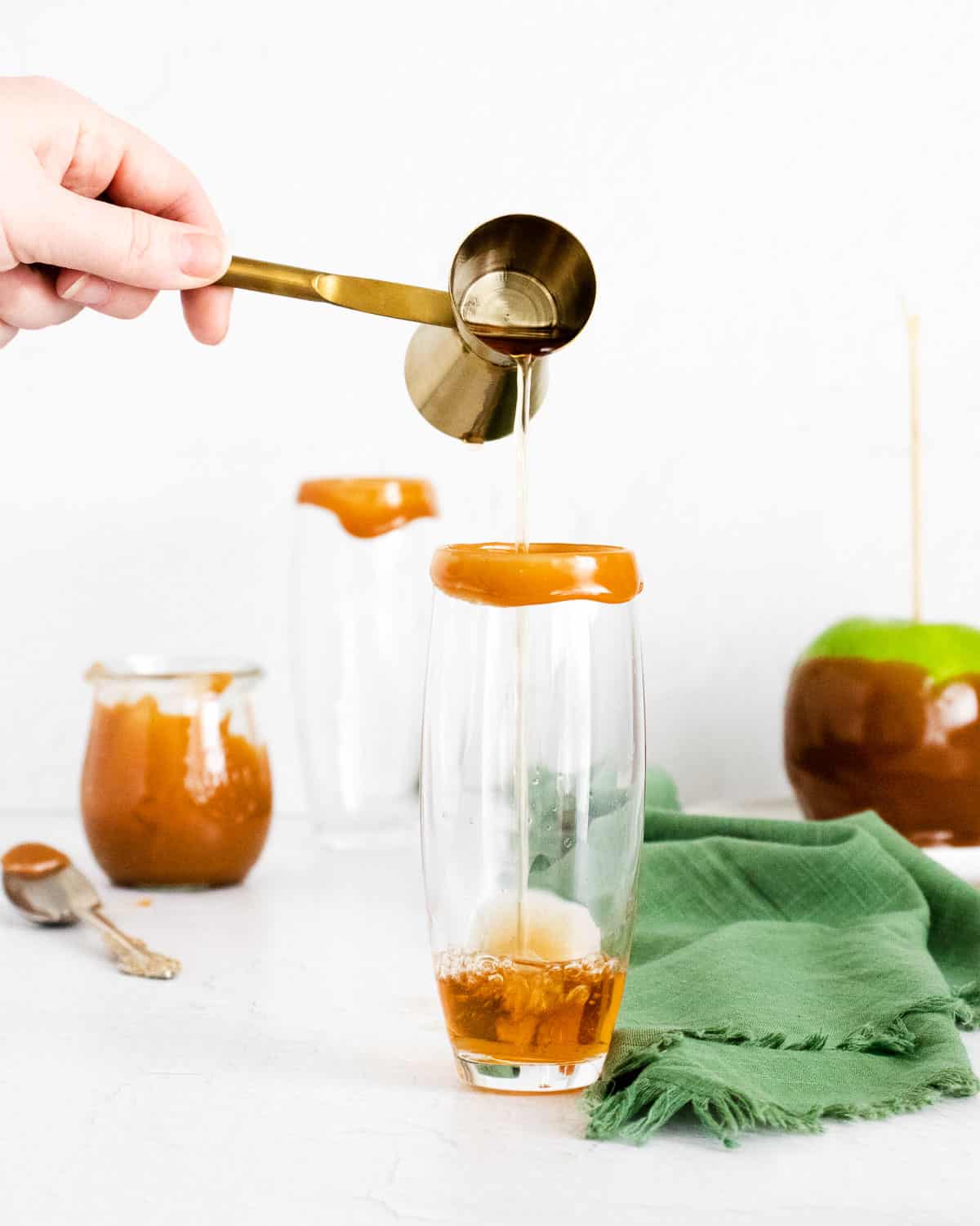 Sidra de manzana siendo vertida en una flauta de champán con borde de caramelo.
