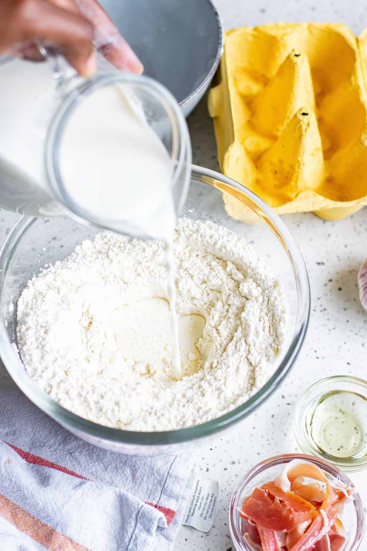 Milk being poured into dry ingredients.