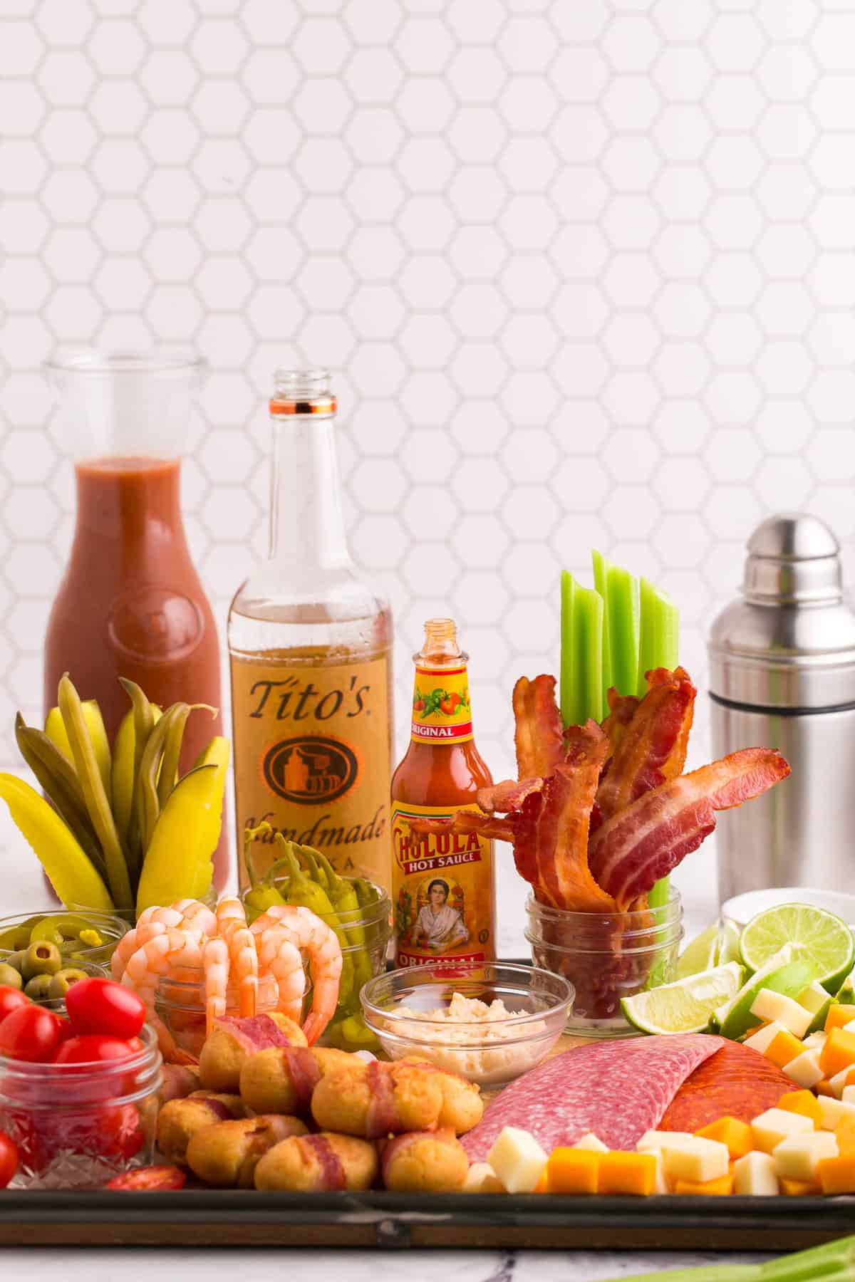 Bar de Bloody Mary montado en una tabla con apio, salsa picante, vodka y más.