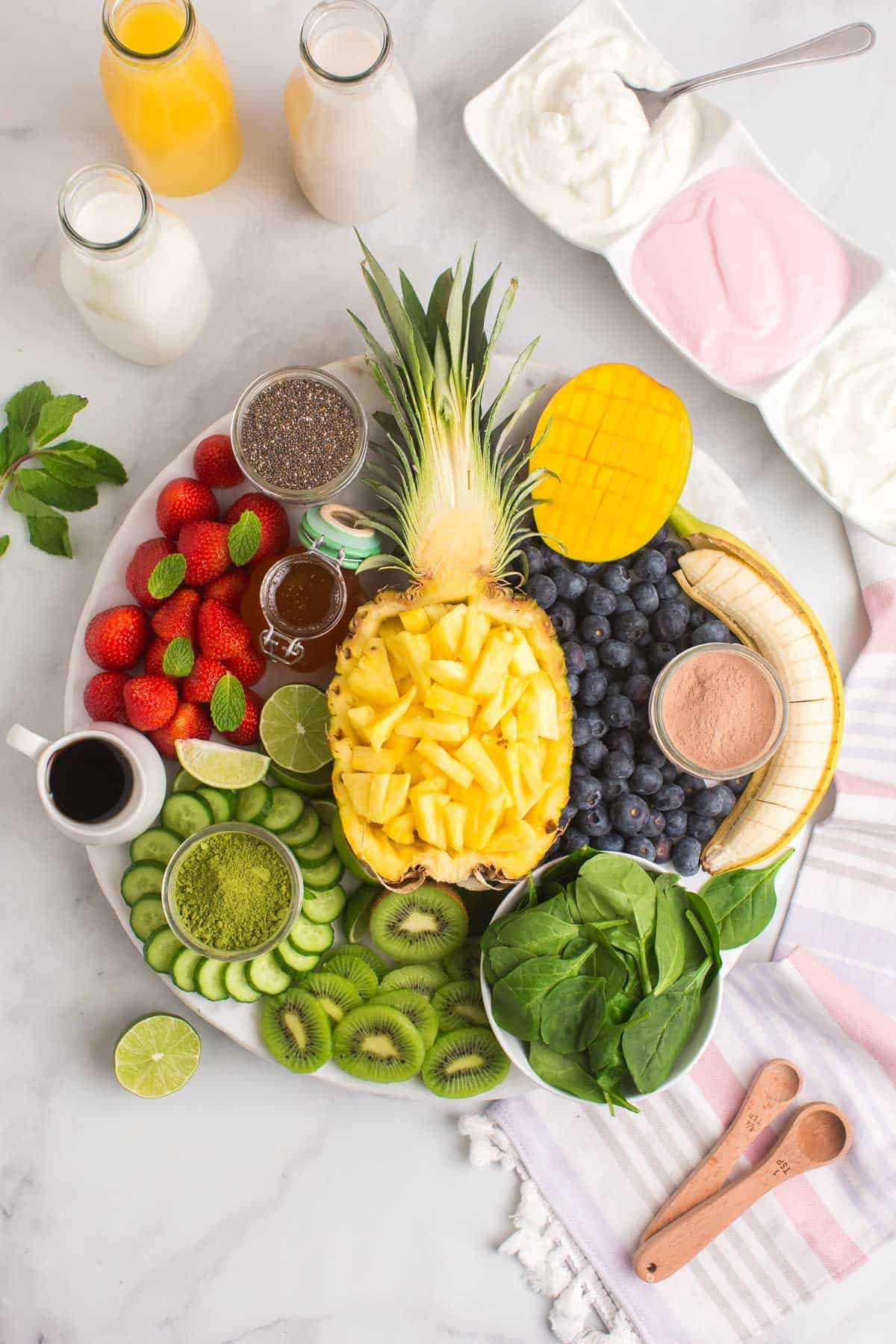 Frutas y variados toppings organizados en una tabla para un bar de batidos.