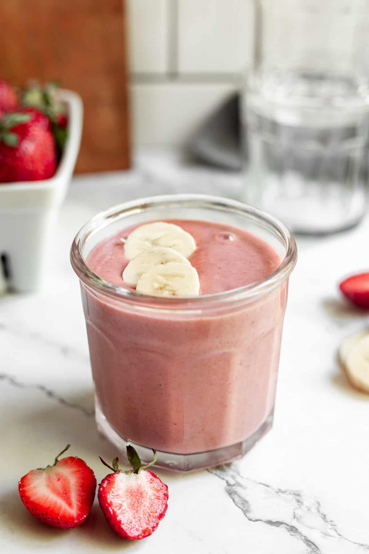 Batido de fresa y plátano con mantequilla de maní decorado con plátanos en rodajas.