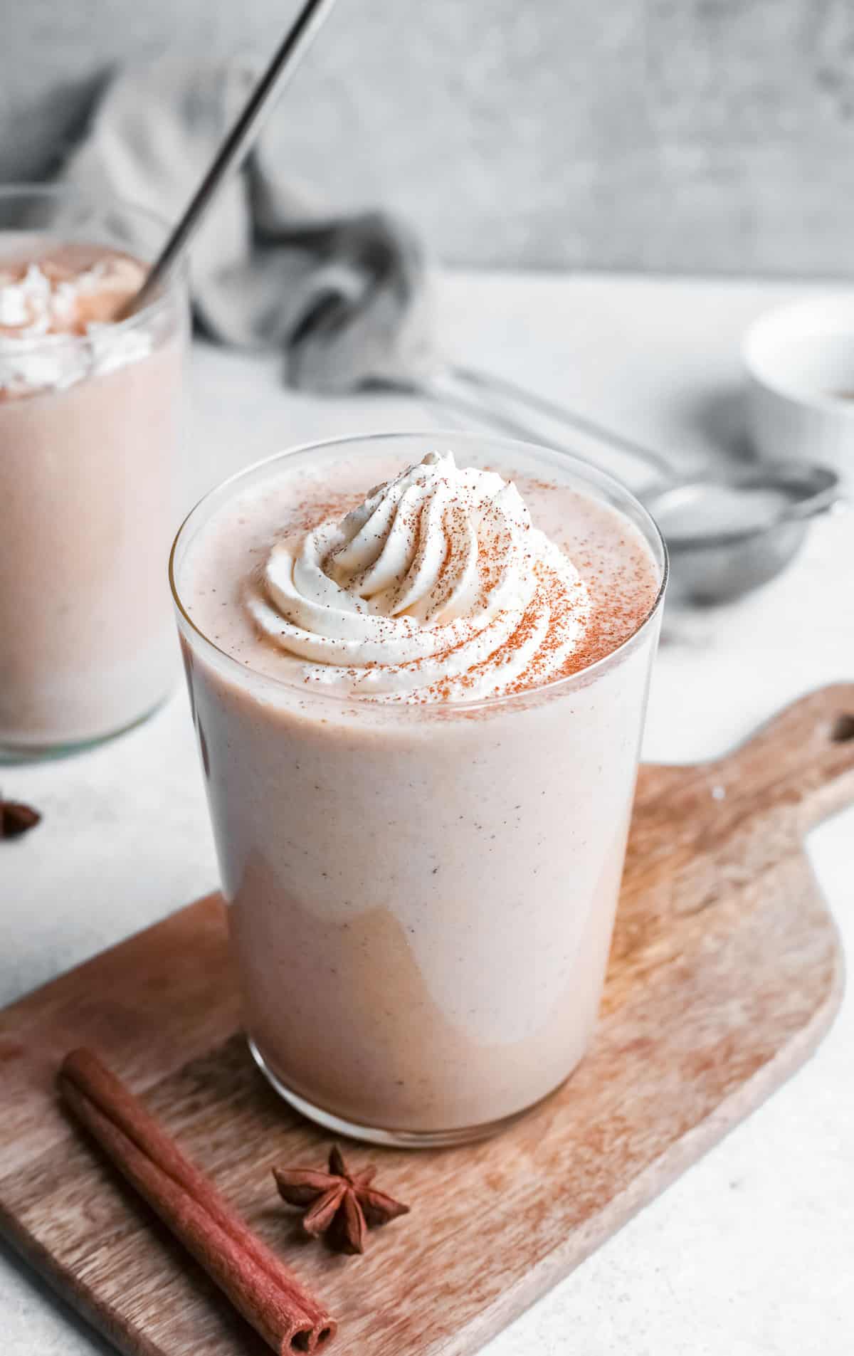 Batido de tarta de calabaza decorado con crema batida y especias de tarta de calabaza.