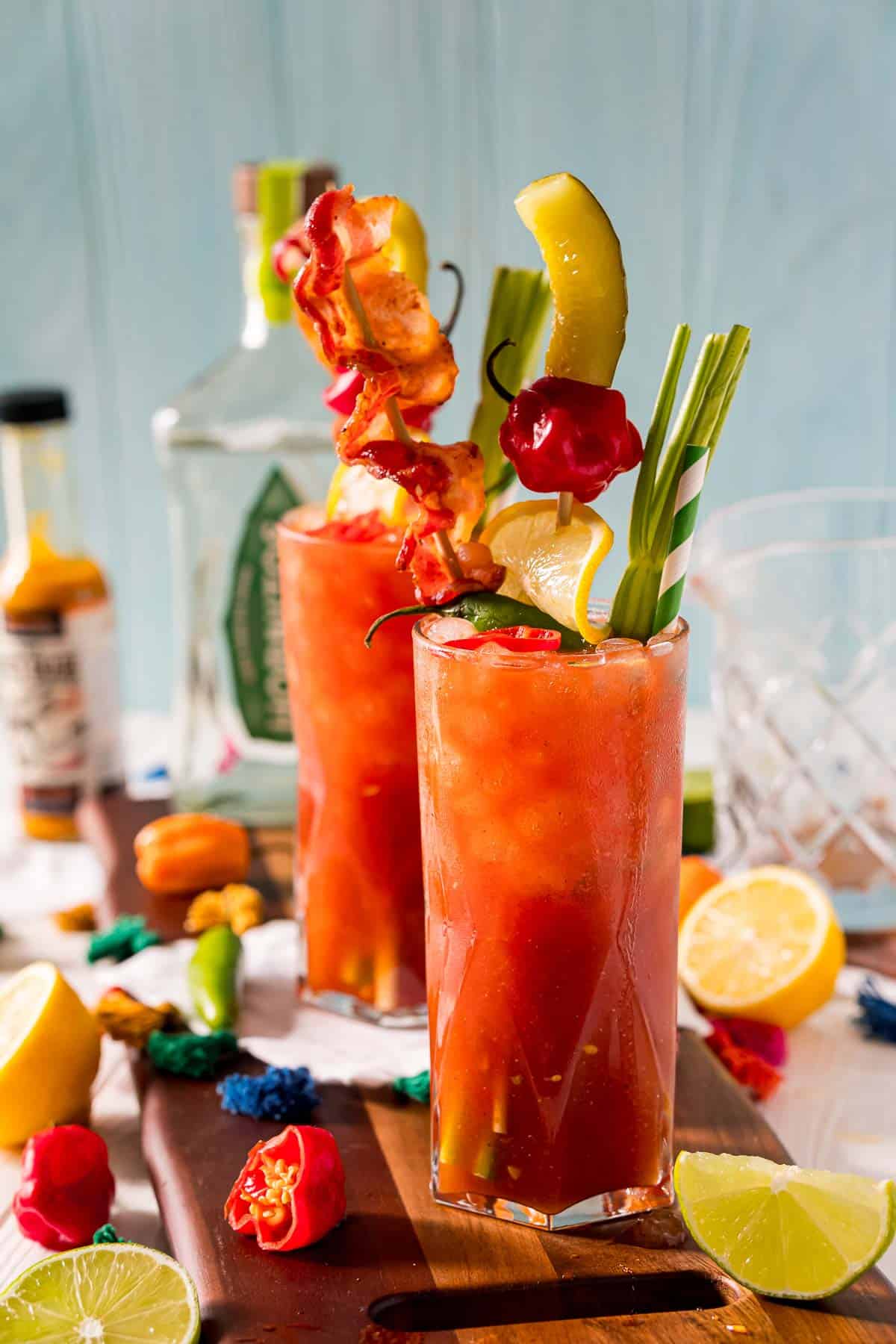 Dos cócteles a base de jugo de tomate, con mucha decoración, en vasos altos.