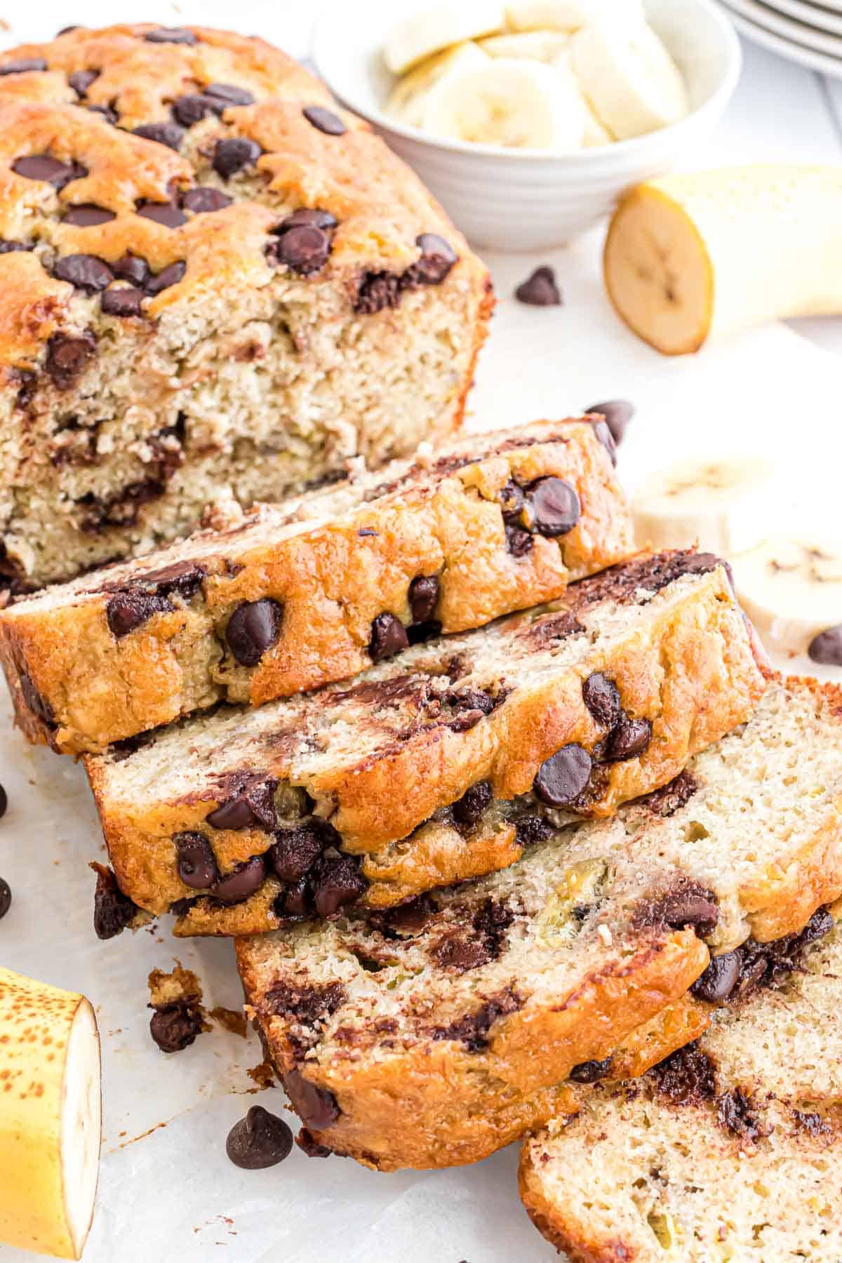 Pan de plátano con mezcla de panqueques y trozos de chocolate, parcialmente rebanado.