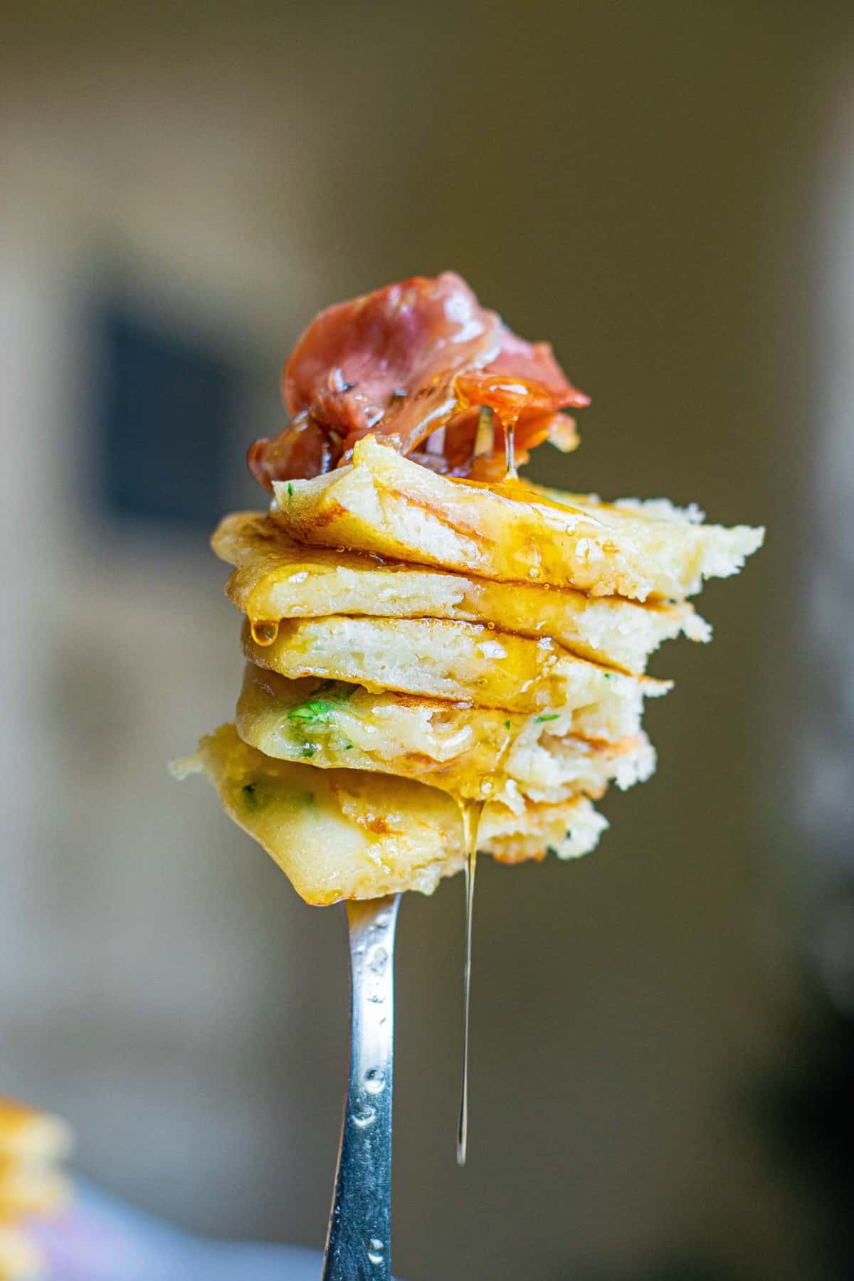 Syrup dripping off of pancakes on a fork